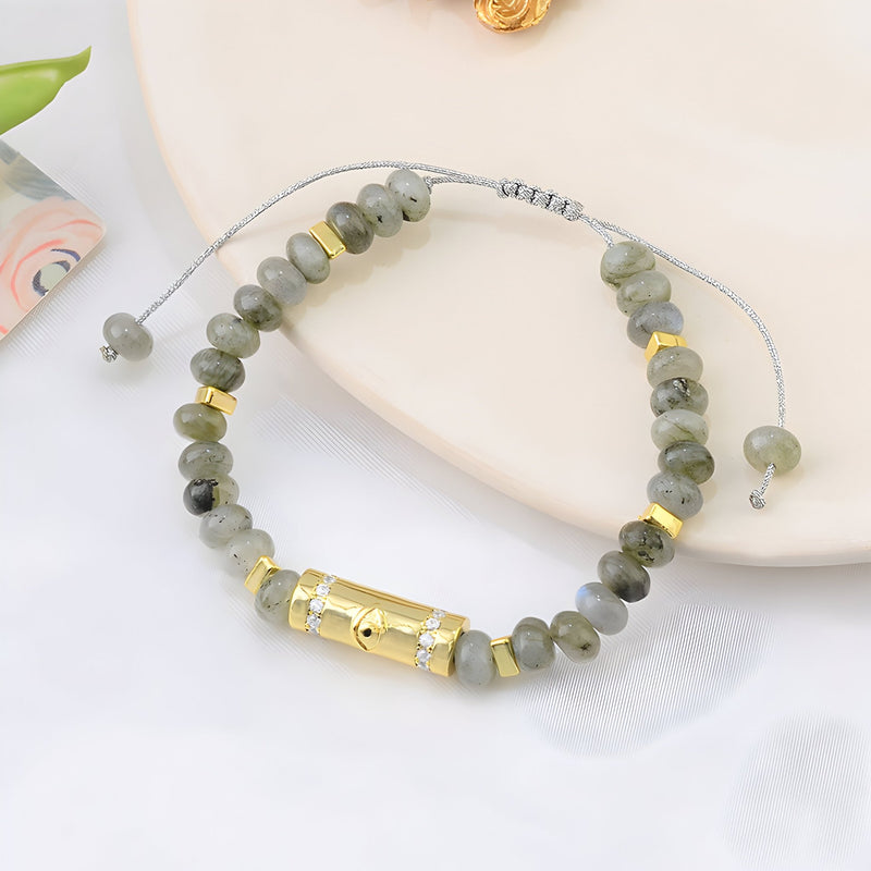 Bracelet femme gris en pierres naturelles ovales et perles dorées avec fermoir cylindrique élégant.