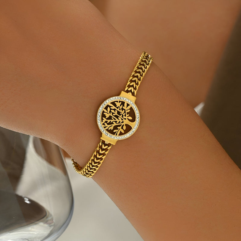 Bracelet femme en titane doré avec pendentif arbre de vie ajouré et chaîne fine tressée.