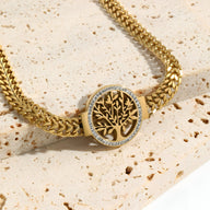 Bracelet femme en titane doré avec pendentif arbre de vie cerclé de petits diamants.