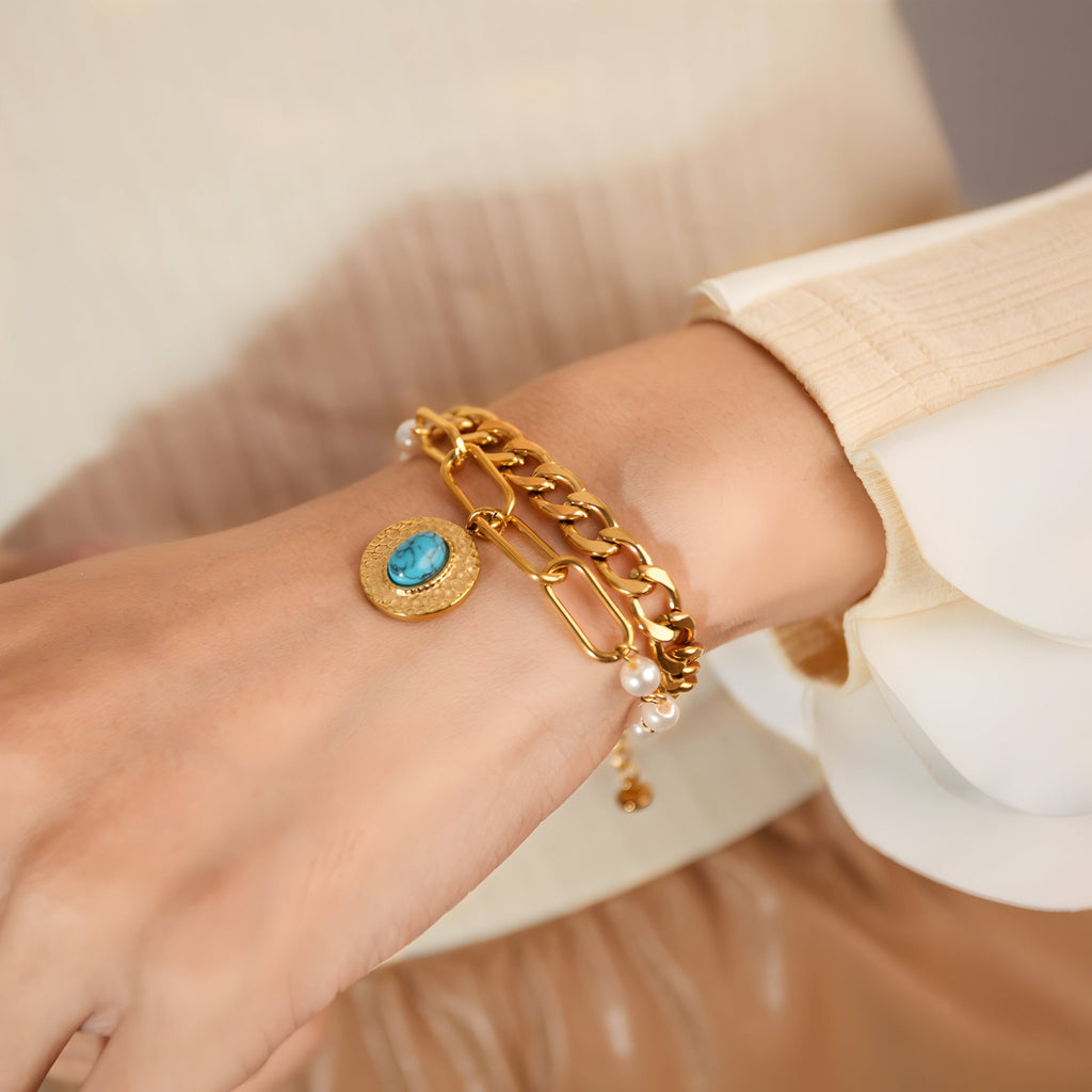 Bracelet femme multi-mailles en acier doré avec pendentif pierre turquoise ovale.