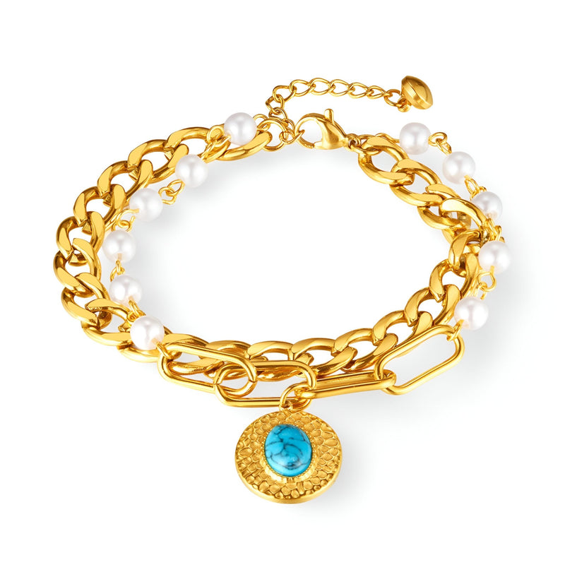 Bracelet femme or multi-chaînes en acier avec perles blanches et pierre turquoise centrale.