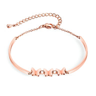 Bracelet femme en acier inoxydable or rosé avec trois papillons en relief et chaîne réglable.