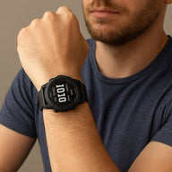 Bracelet noir en maille milanaise en acier inoxydable pour montre connectée Garmin, porté au poignet.