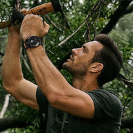 Bracelet noir en nylon résistant avec attache tactique sur montre connectée Garmin, porté par un homme en extérieur.