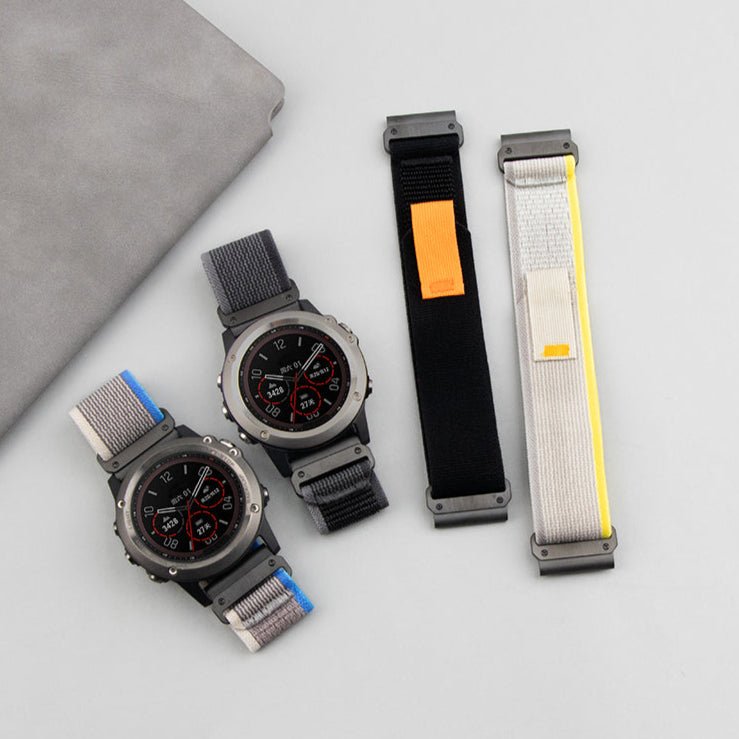 Bracelet pour montre connectée en nylon gris clair avec surpiqûres bleues et boucle noire, compatible Garmin.