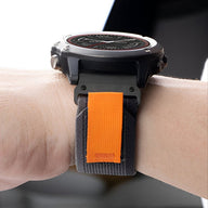 Bracelet de montre connecté en nylon gris avec attache velcro orange, style robuste et ajustable.