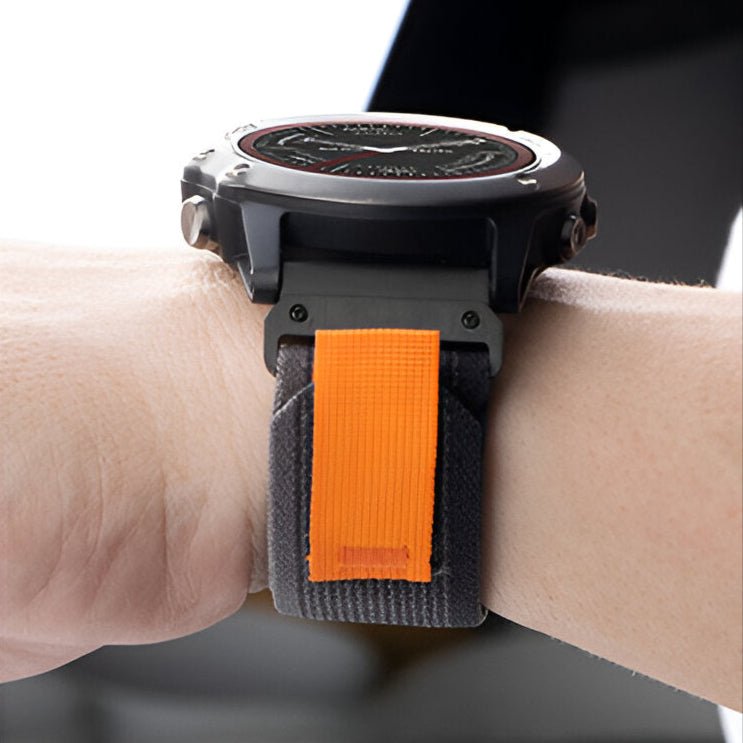 Bracelet de montre connecté en nylon gris avec attache velcro orange, style robuste et ajustable.