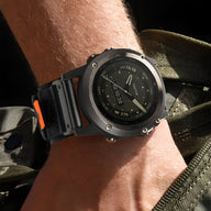 Bracelet montre connectée noir en nylon résistant avec attache velcro orange et coutures renforcées.