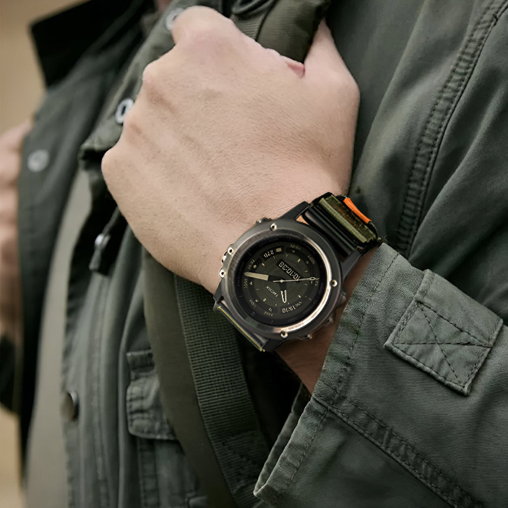 Bracelet montre connecté nylon kaki avec attache velcro noire, style tactique, porté au poignet.