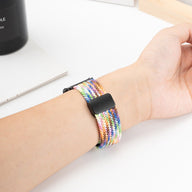 Bracelet montre connecté en nylon multicolore tressé avec fermoir magnétique noir.