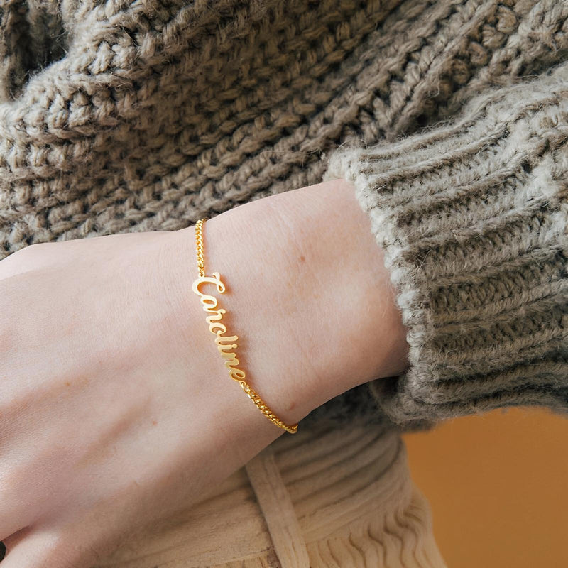 Bracelet ajustable en acier inoxydable doré avec prénom personnalisé en lettres cursives.