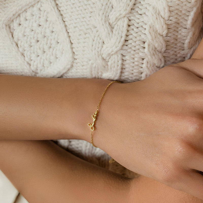 Bracelet prénom personnalisé en acier doré, chaîne fine ajustable avec lettres en script délicat.
