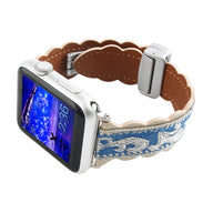 Bracelet en cuir brodé bleu et beige avec motifs floraux, boucle argentée ajustable pour Apple Watch.