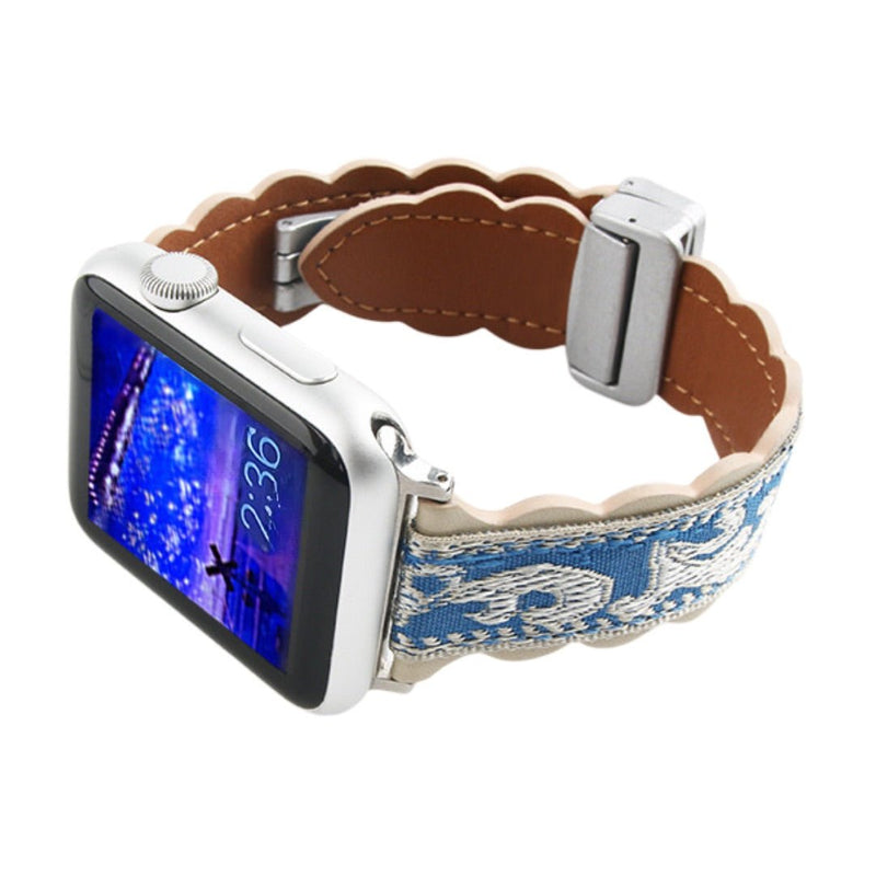 Bracelet en cuir brodé bleu et beige avec motifs floraux, boucle argentée ajustable pour Apple Watch.