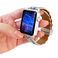 Bracelet Apple Watch cuir brodé beige à motifs bleus avec boucle argentée, ajustable, style féminin.