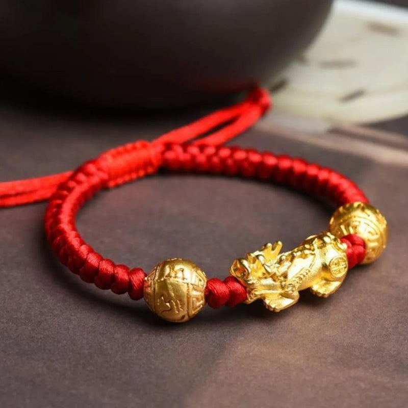 Bracelet tibétain en fil rouge ciré avec Pi Xiu doré et perles dorées sculptées.