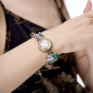 Bracelet rétro multicolore pour femme avec pendentifs variés dont un cœur et un anneau décoratif en métal doré.