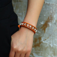 Bracelet rétro en cuir orange avec cordes blanches tressées en croix, style homme.