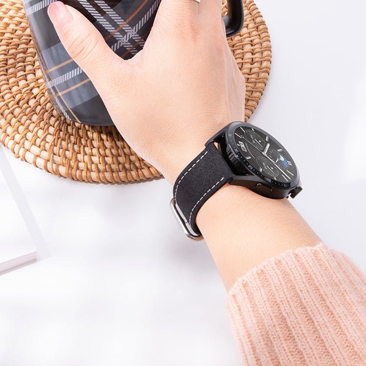 Bracelet de montre en nylon noir avec boucle ardillon argentée, finition contrastante blanche, style casual et résistant.