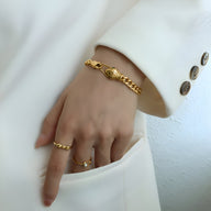 Bracelet serpent doré 18 carats avec yeux verts, design fin et élégant porté au poignet.