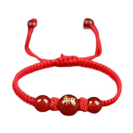 Bracelet en nylon fil rouge avec perles rouges et symbole doré du signe du zodiaque chinois Tigre.