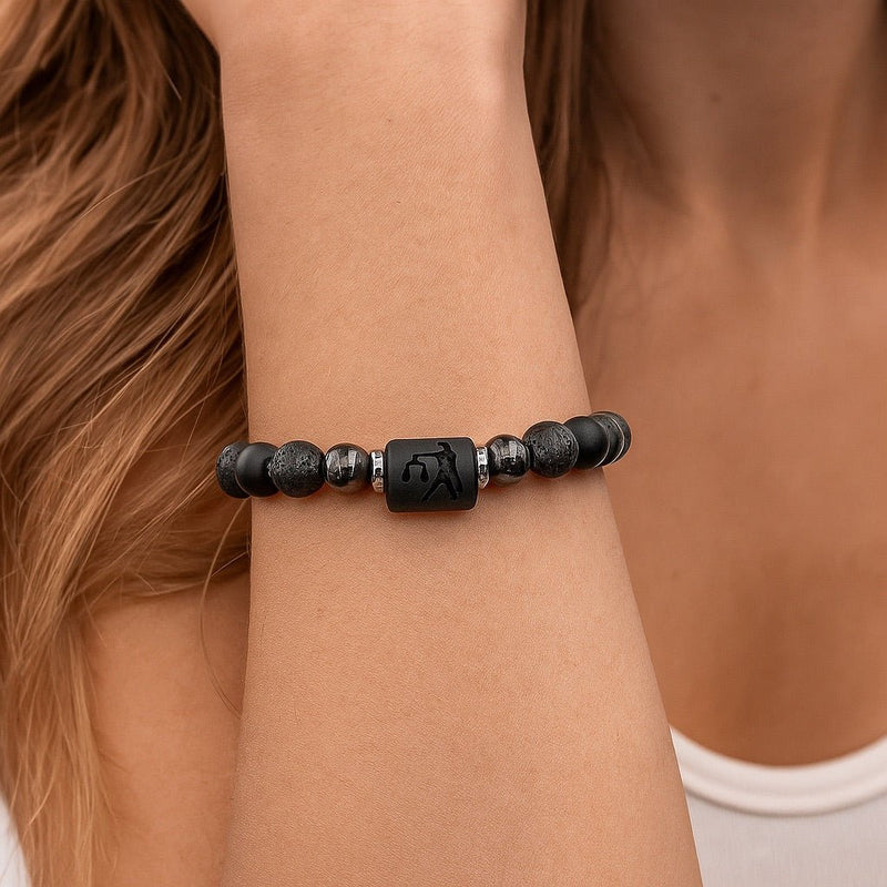 Bracelet élastique mixte en perles noires, pierres de lave texturées, hématite brillante et perle centrale carrée gravée du.