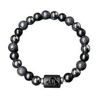 Bracelet élastique noir avec perles de lave texturées, hématite brillante et un bead central gravé du signe astrological.