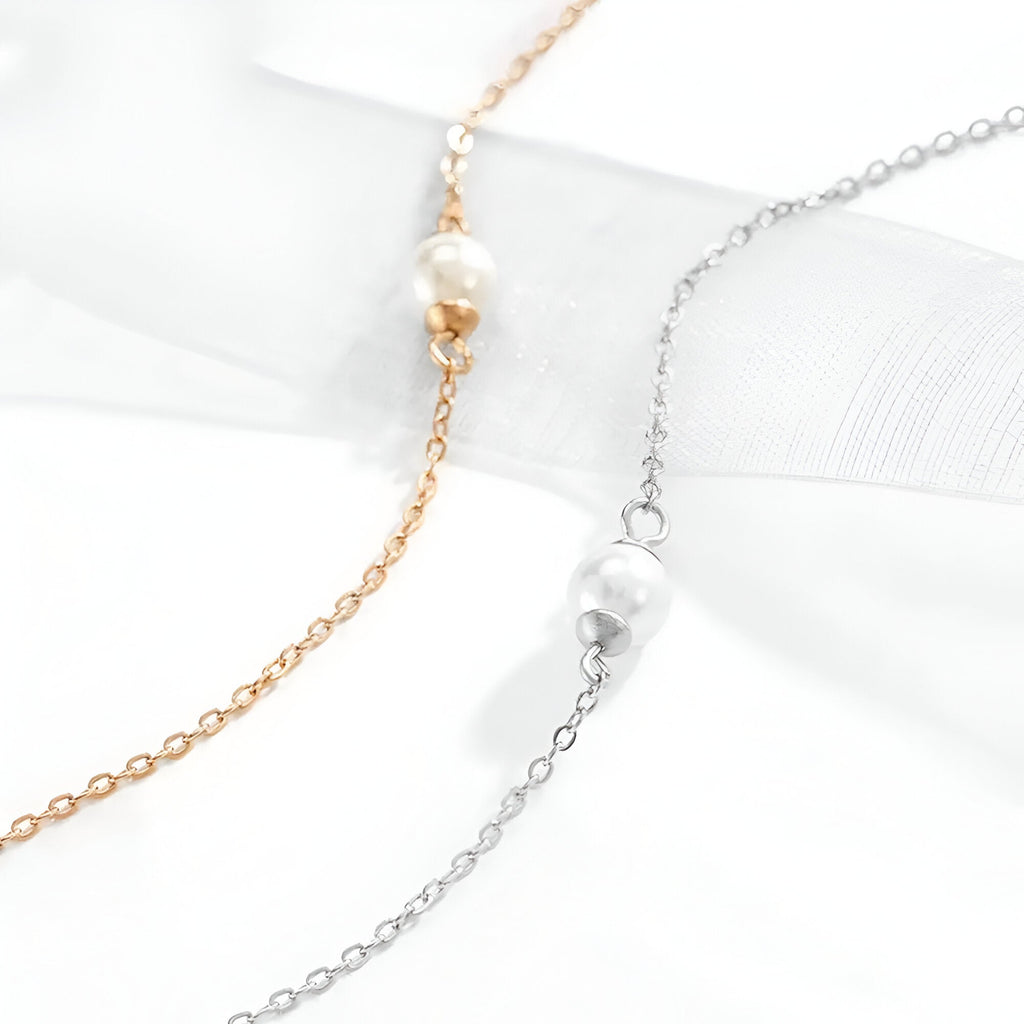 Bracelet en acier inoxydable avec chaîne fine et perle centrale, modèle Drisana, coloris or et argent.