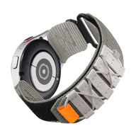 Bracelet Sport Edition en nylon gris avec fermoir velcro noir et détail orange pour montre connectée Samsung Galaxy Watch.