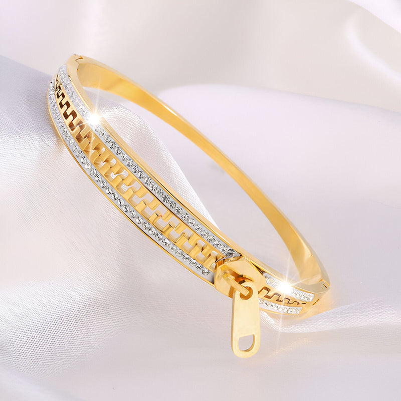 Bracelet femme en titane doré, design fermeture éclair avec détails argentés brillants.