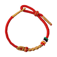 Bracelet serpent en fil rouge ciré avec détails dorés et perles colorées, ajustable, unisexe.