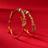 Bracelet serpent en fil rouge ciré avec têtes serpent dorées et perles colorées, ajustable.