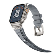 Bracelet Apple Watch gris en silicone résistant, fermoir ardillon argenté, design tactique ajustable.