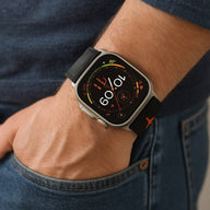 Bracelet tactique noir avec logo orange pour Apple Watch, style ajustable et magnétique.