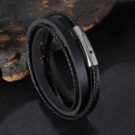 Bracelet tressé en cuir noir multi tours avec fermoir métallique argenté brillant.