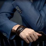 Bracelet tressé en cuir marron multi tours porté au poignet, style moderne et élégant.