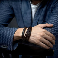 Bracelet tressé en cuir marron multi tours porté au poignet, style élégant et moderne.