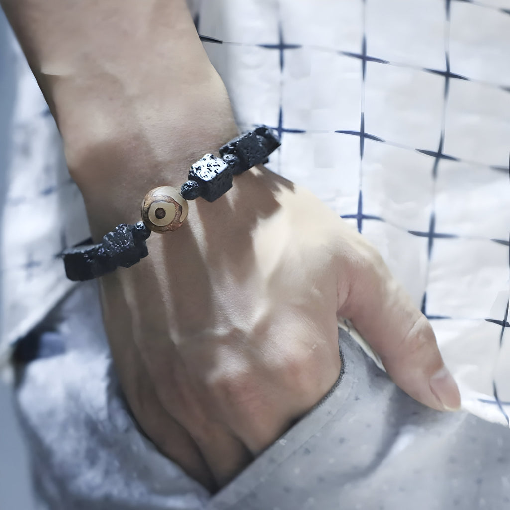 Bracelet tibétain noir en pierres volcaniques cubiques avec perle de Dzi centrale, style mixte.