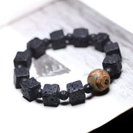 Bracelet mixte noir en pierres volcaniques cubiques avec perle de Dzi marron, style tibétain.