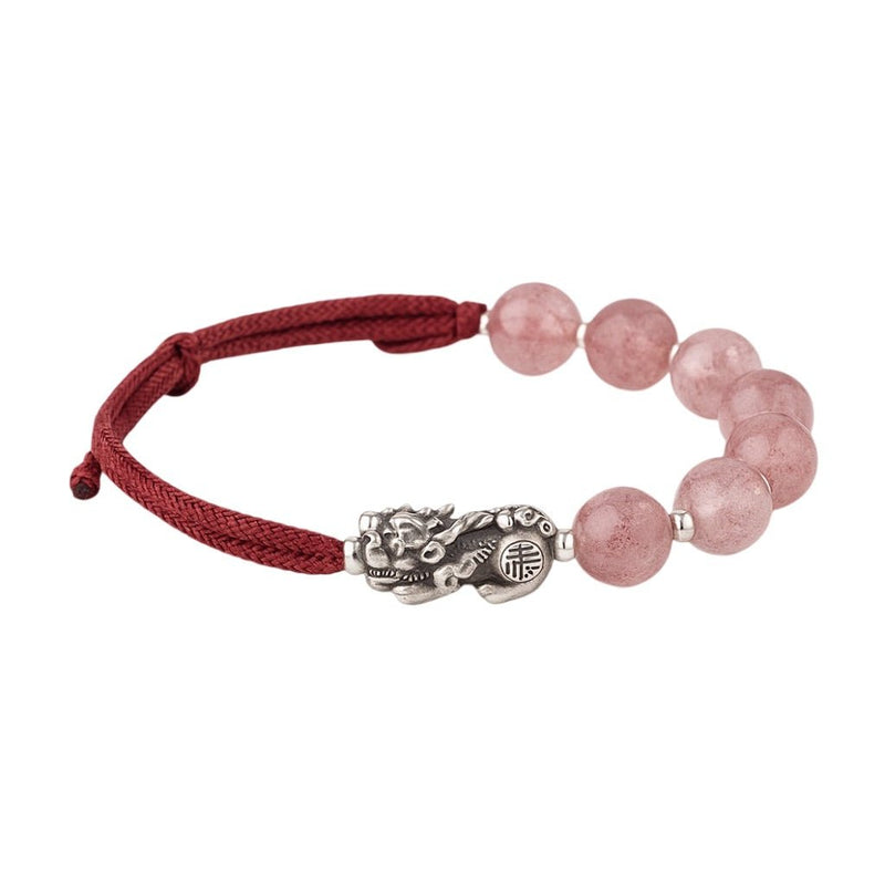 Bracelet tibétain avec perles en quartz rose et pendentif Pi Xiu argenté sur fil rouge ajustable.