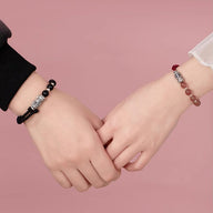 Bracelet tibétain Pi Xiu en obsidienne noire avec breloque argentée sur fil rouge, porté en duo.