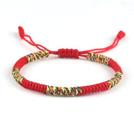 Bracelet tibétain en nylon fil rouge avec tressage coloré multicolore et fermoir coulissant.