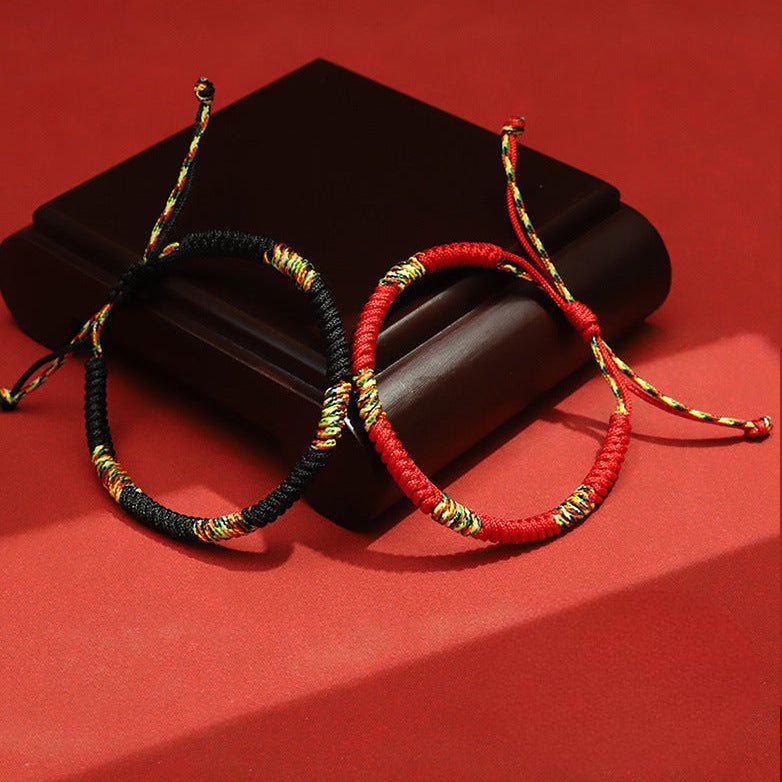 Bracelet tibétain fil rouge tressé avec détails multicolores, modèle Alimo, livré avec version noire similaire.