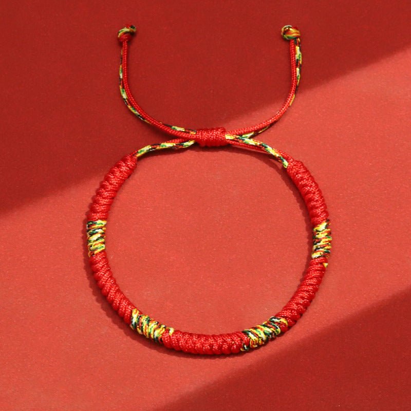Bracelet tibétain en nylon fil rouge avec motifs colorés et réglable par nœud coulissant.