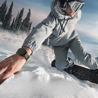 Bracelet Trail Edition en nylon vert olive avec fermoir velcro sur montre connectée Samsung Galaxy Watch portée en snowboard .