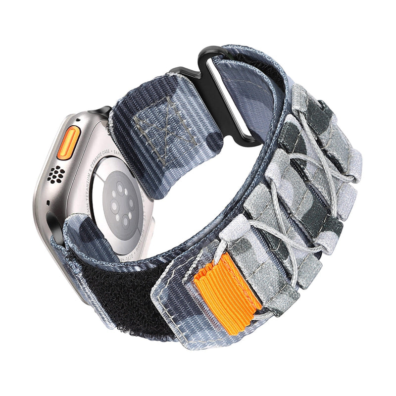 Bracelet Apple Watch Trail Edition en nylon gris avec fermeture velcro orange et nœuds tactiques robustes.