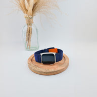 Bracelet Apple Watch en nylon bleu marine avec boucle velcro orange et noire, modèle Elios.