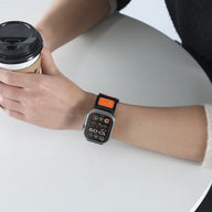 Bracelet Apple Watch en nylon noir et orange, drapeau américain, ajustable, modèle Vino, porté au poignet.