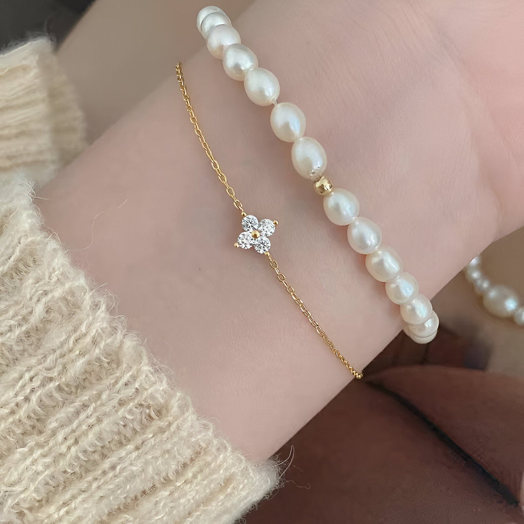 Bracelet fin en cuivre doré avec pendentif trèfle à 4 feuilles orné de strass scintillants.