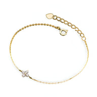 Bracelet fin en cuivre doré avec pendentif trèfle à 4 feuilles orné de strass scintillants.